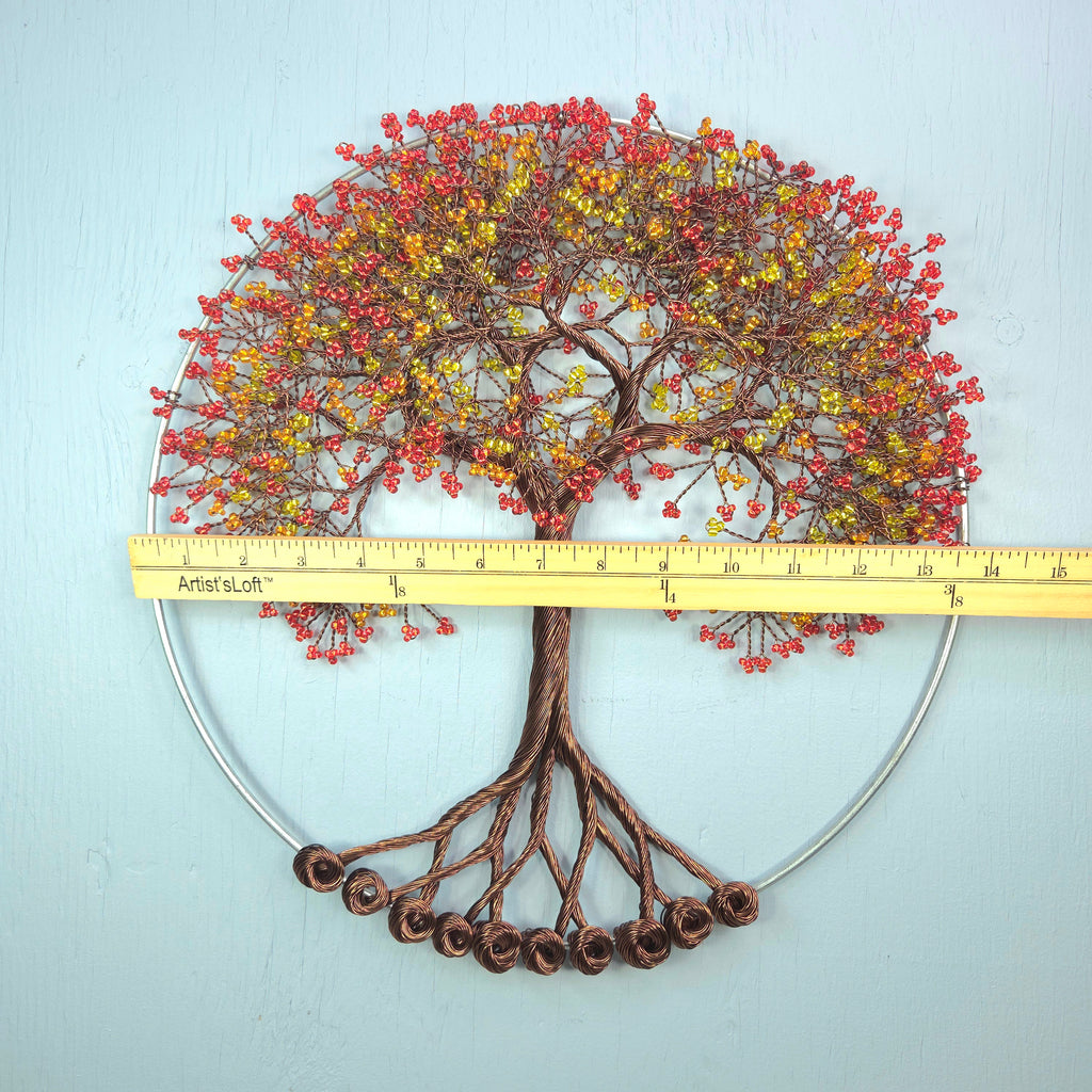 Decorative metal tree wall art with a ruler for scale on a light blue background