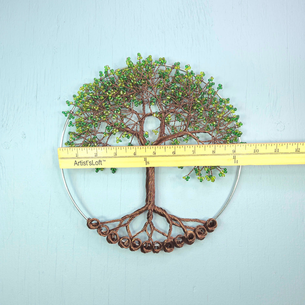 Decorative tree wall art with a ruler for scale on a light blue background