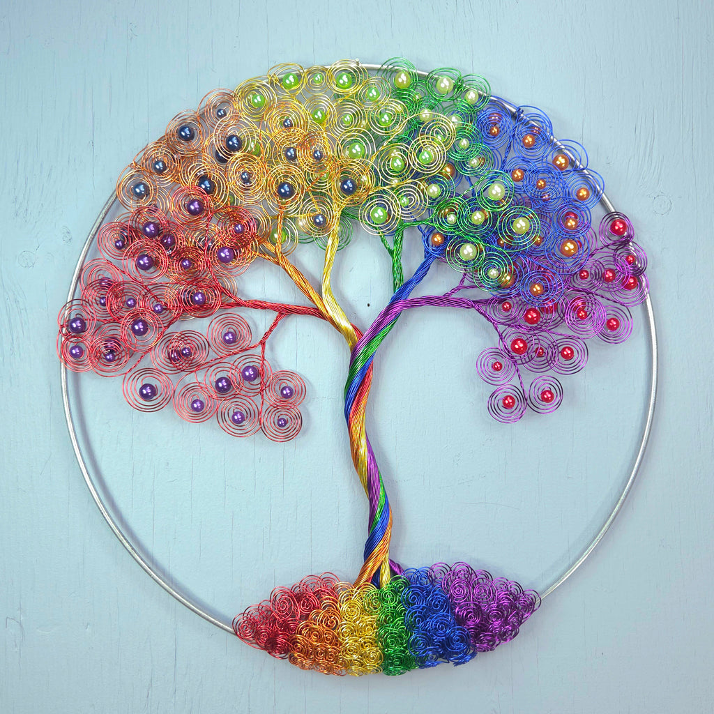 Colorful tree-shaped decorative item with beads on a light blue background