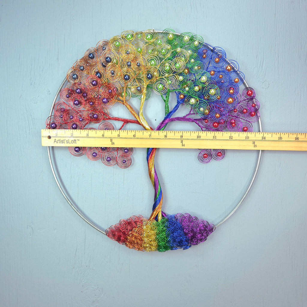 Colorful wreath with a rainbow pattern and a measuring tape for scale on a light blue background