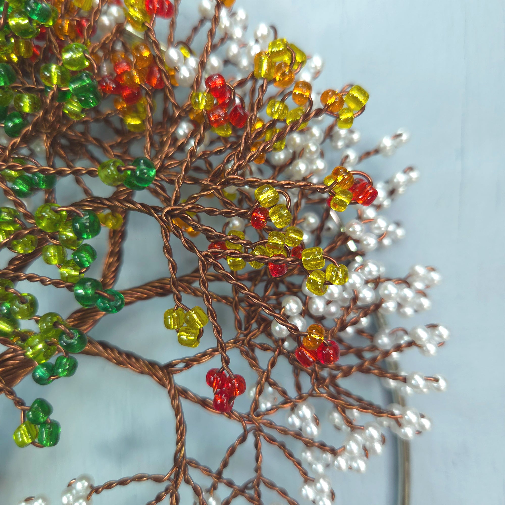 Decorative branch with colorful beads on a light blue background