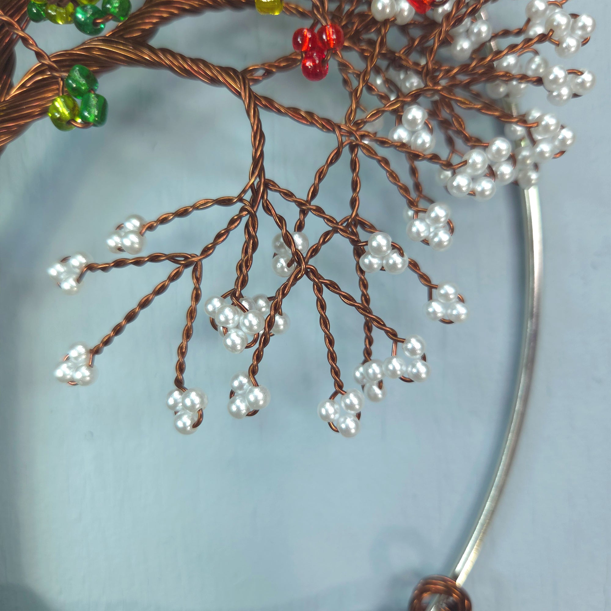 Decorative branch with beads on a light blue background