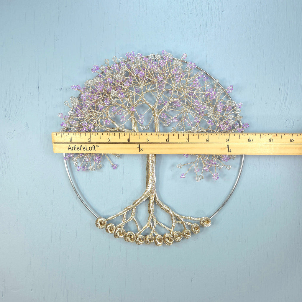 Decorative metal tree wall art with a ruler for scale on a light blue background