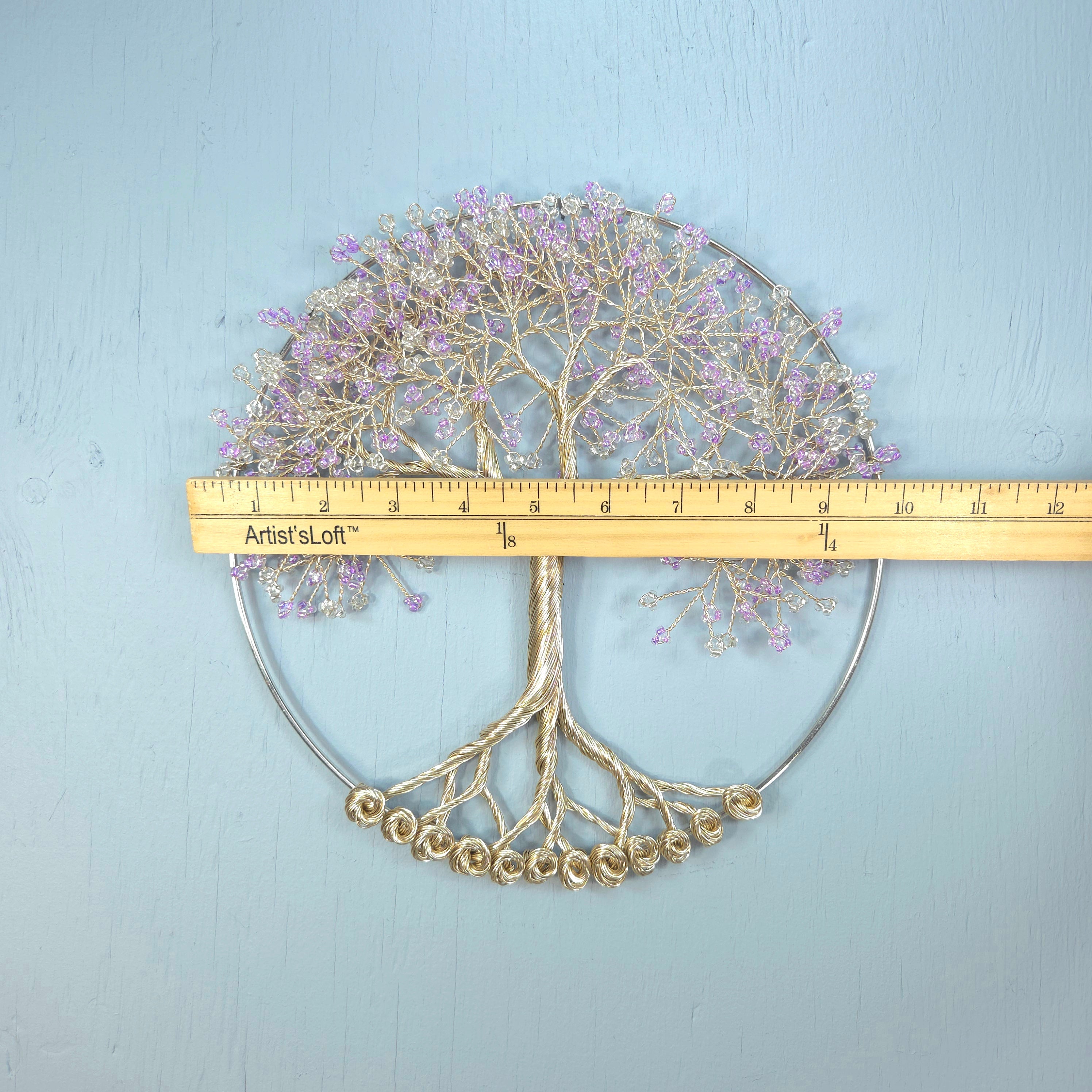 Decorative metal tree wall art with a ruler for scale on a light blue background