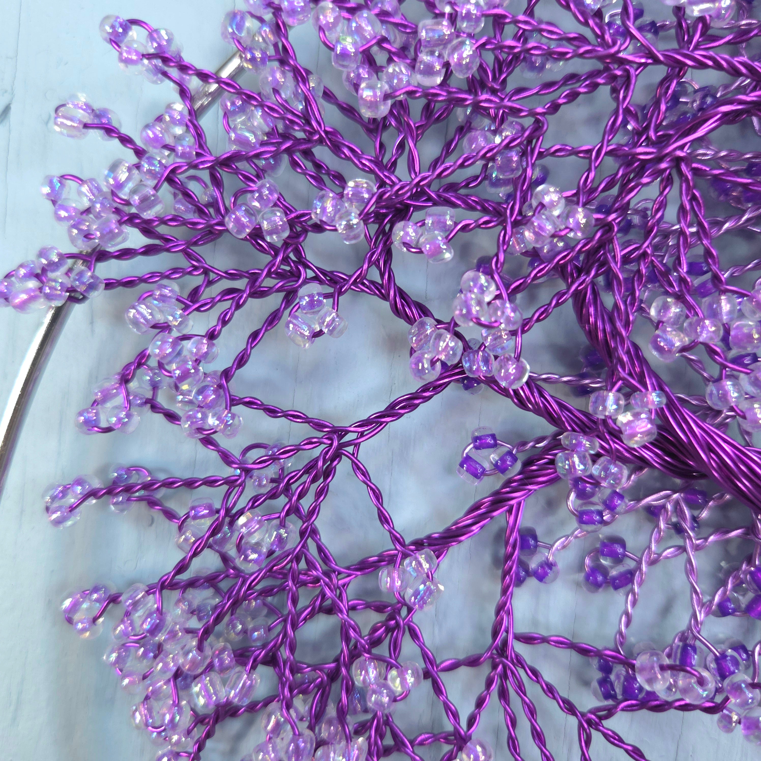 Purple decorative branch with beads on a light blue background