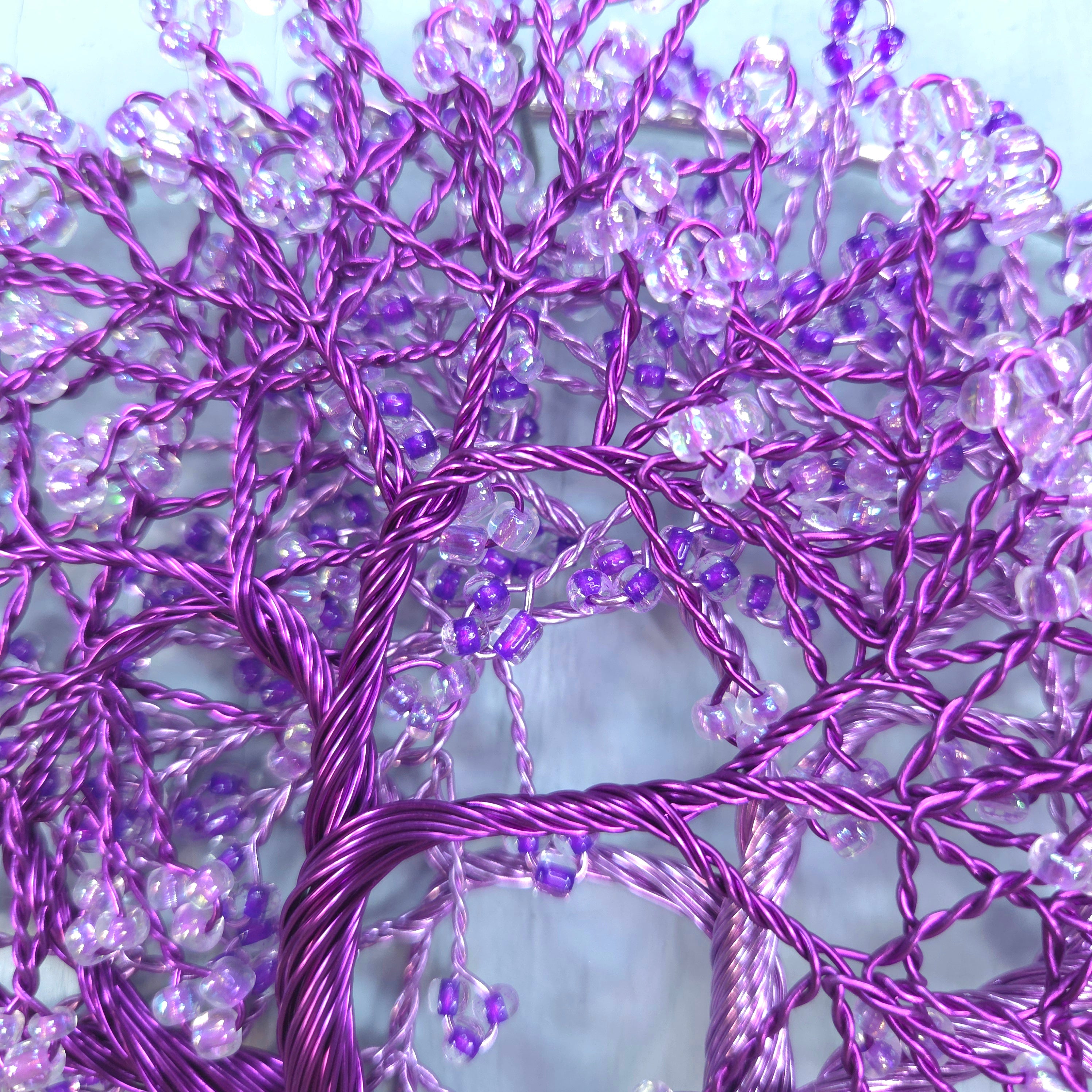 Decorative purple tree made of string lights against a light blue background