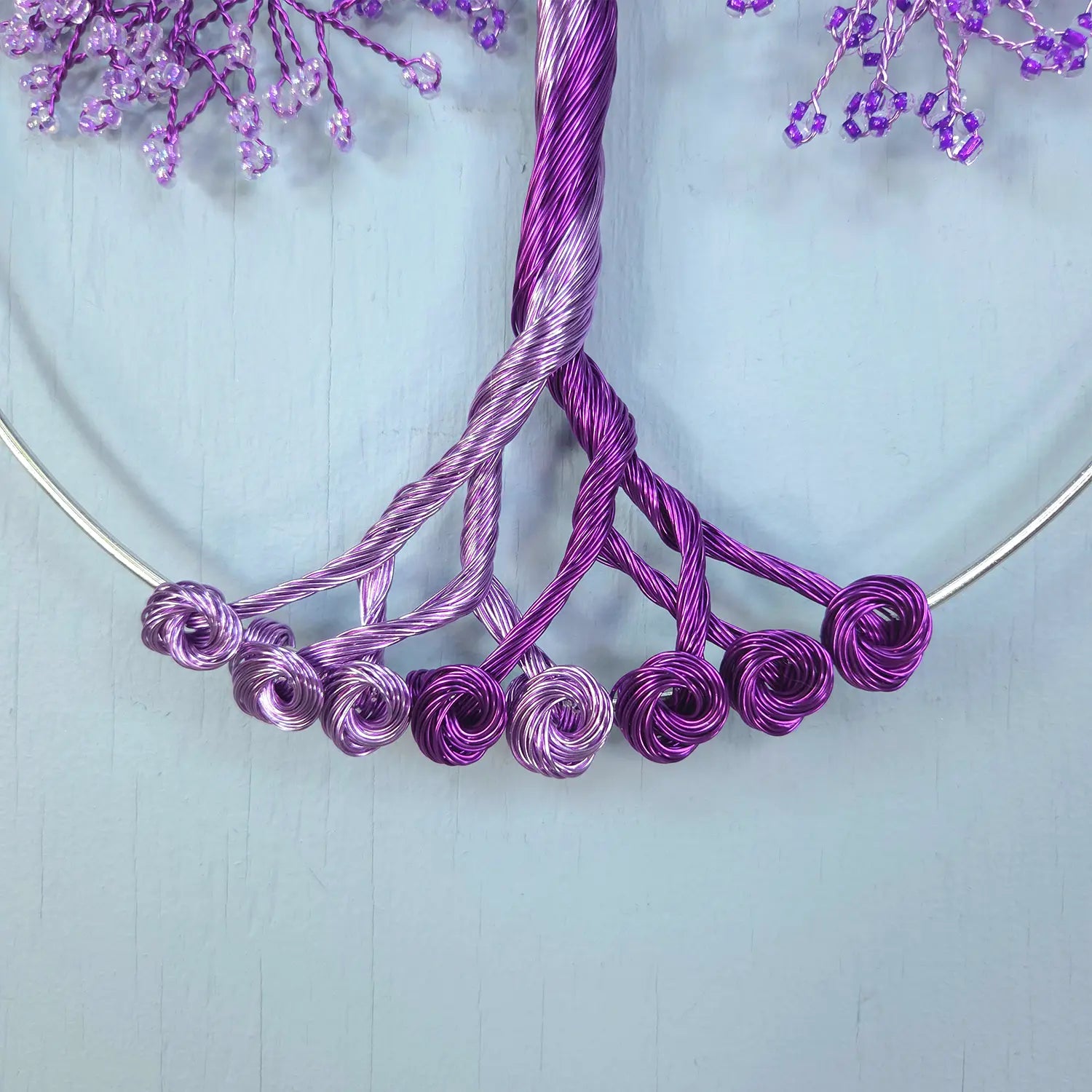 Purple wire jewelry on a light blue background