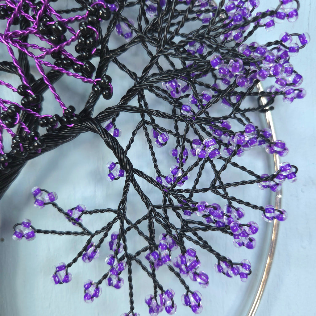 Close-up of beaded branches with purple beads on a white background