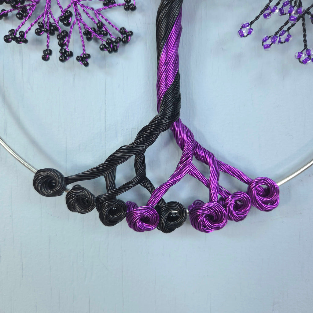 Necklace with black and purple twisted wire design on a light blue background