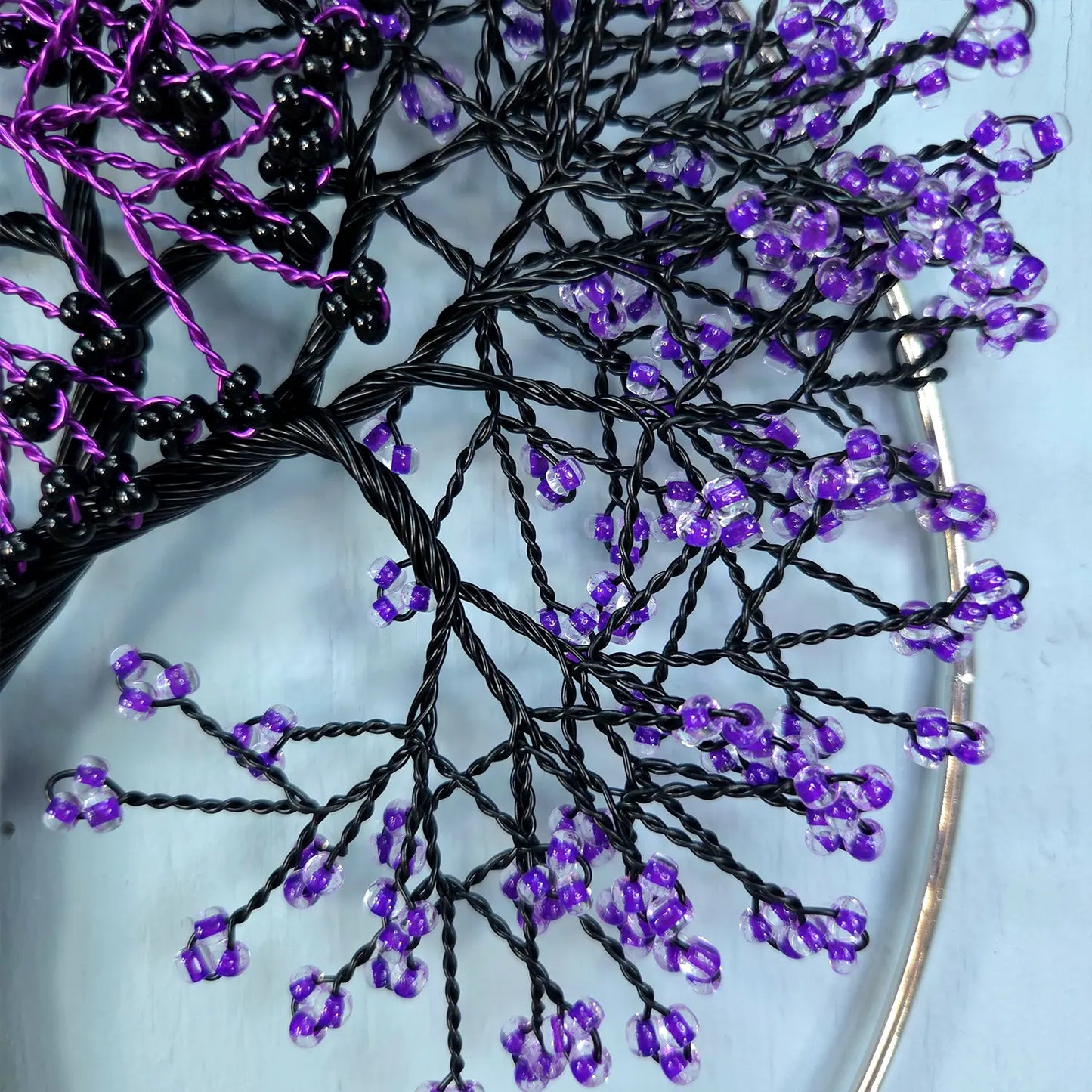 Close-up of a decorative hair accessory with purple beads on a white background