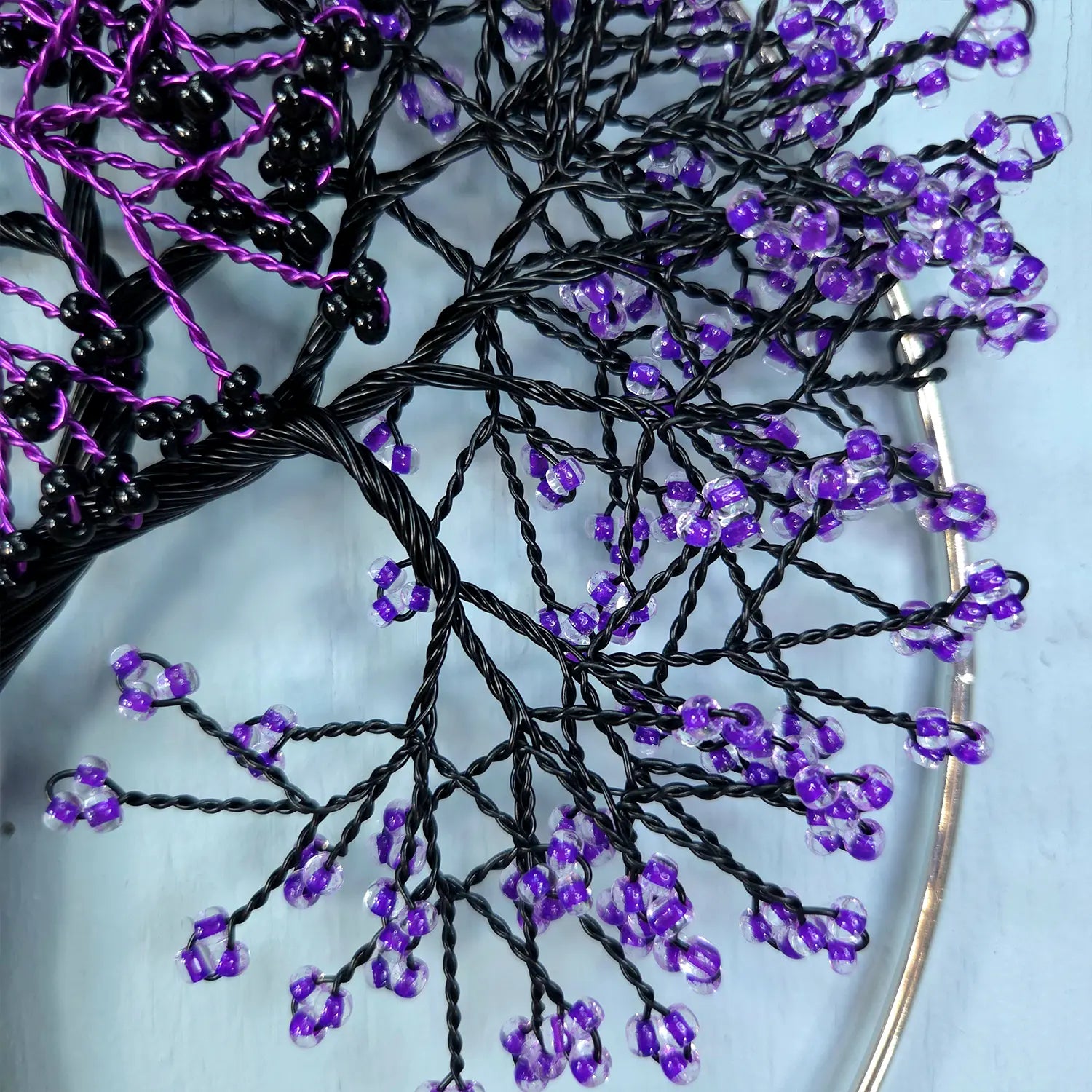 Close-up of a decorative hair accessory with purple beads on a white background