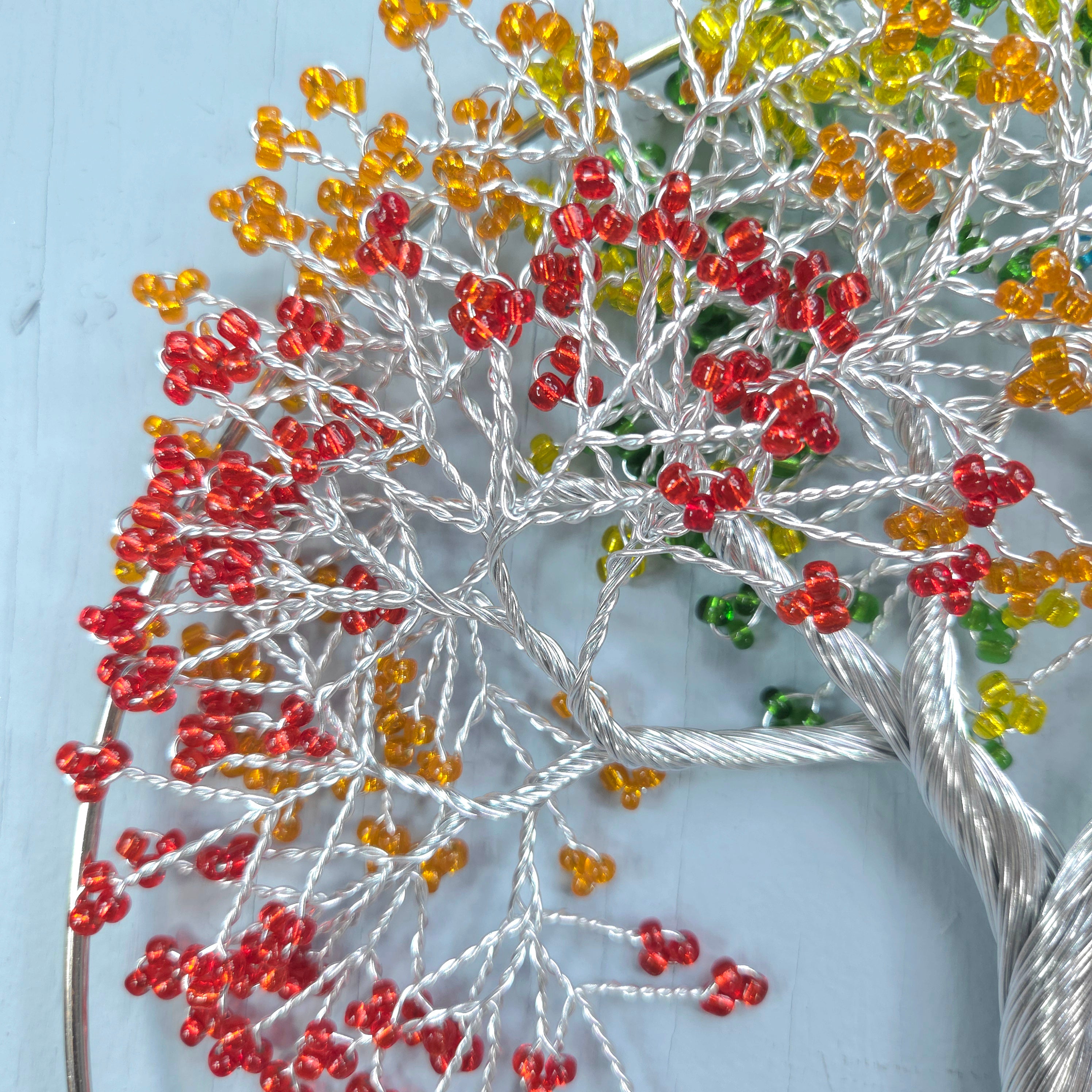 Decorative branch with red and yellow beads on a light blue background