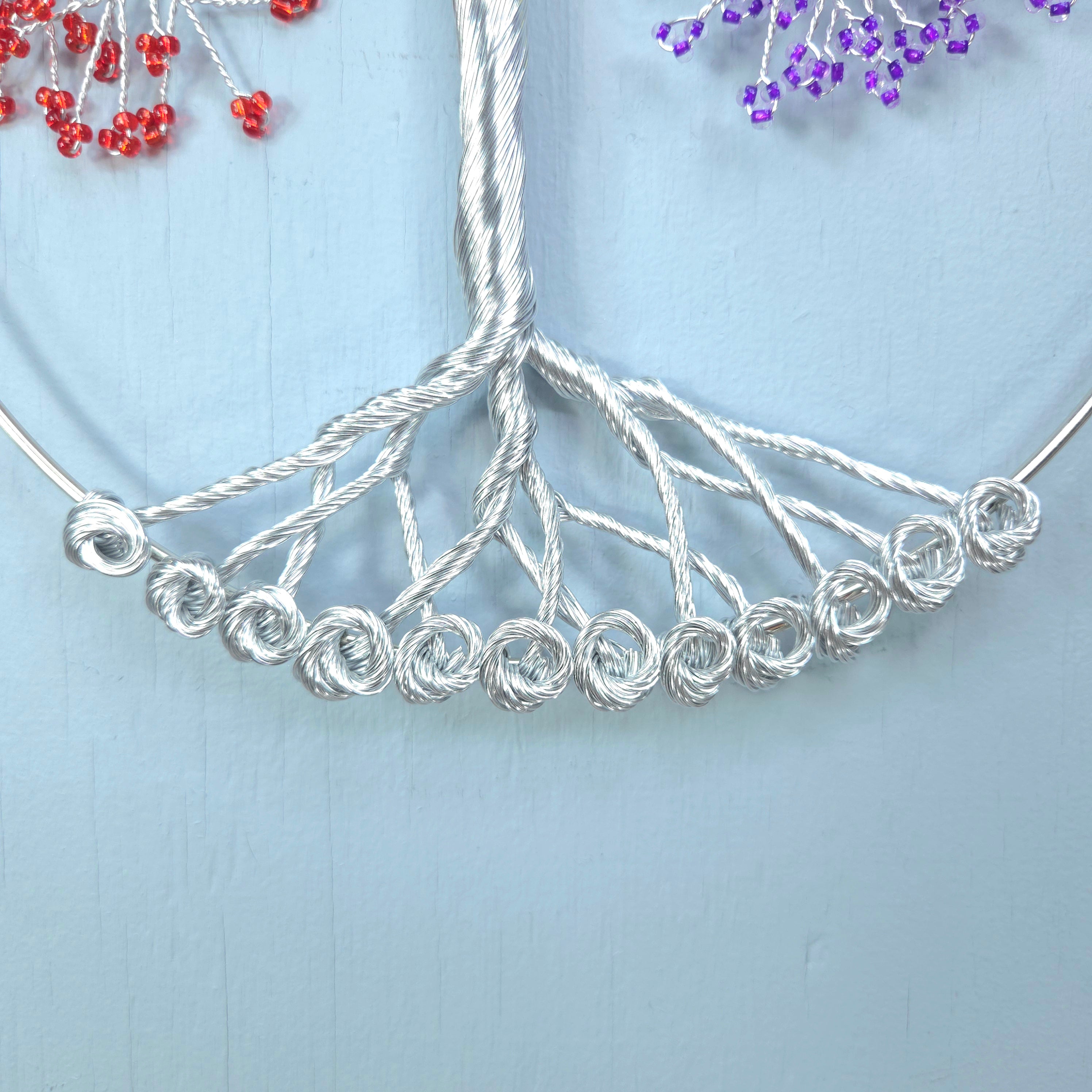Silver beaded necklace on a light blue background