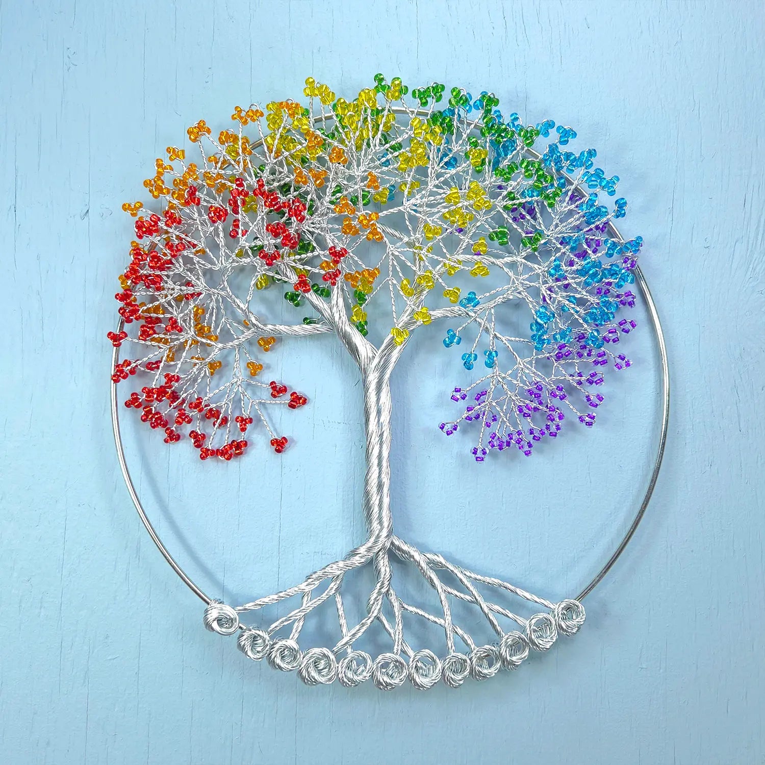 Colorful tree of life wall art on a light blue background