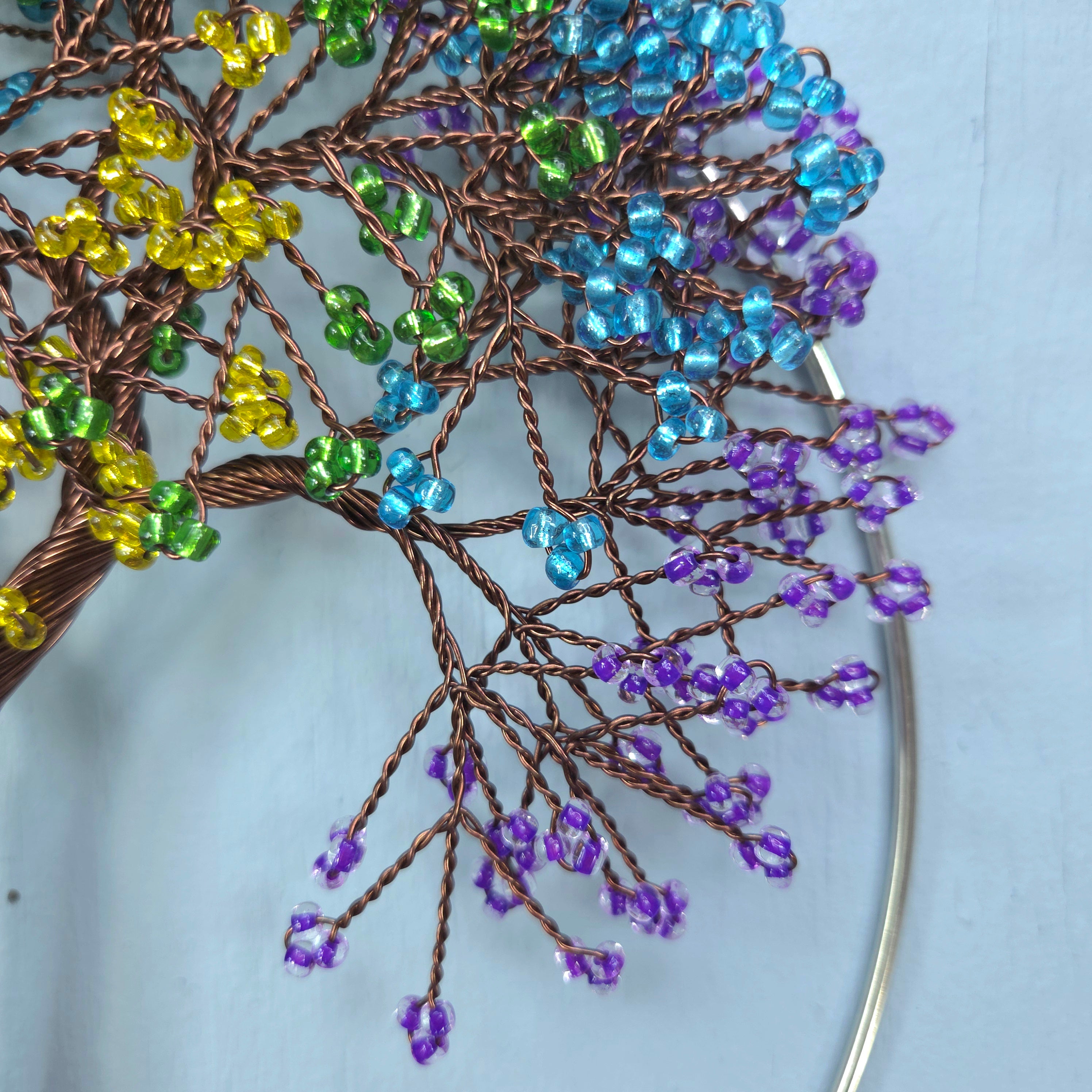 Decorative tree made of wire and beads on a light blue background