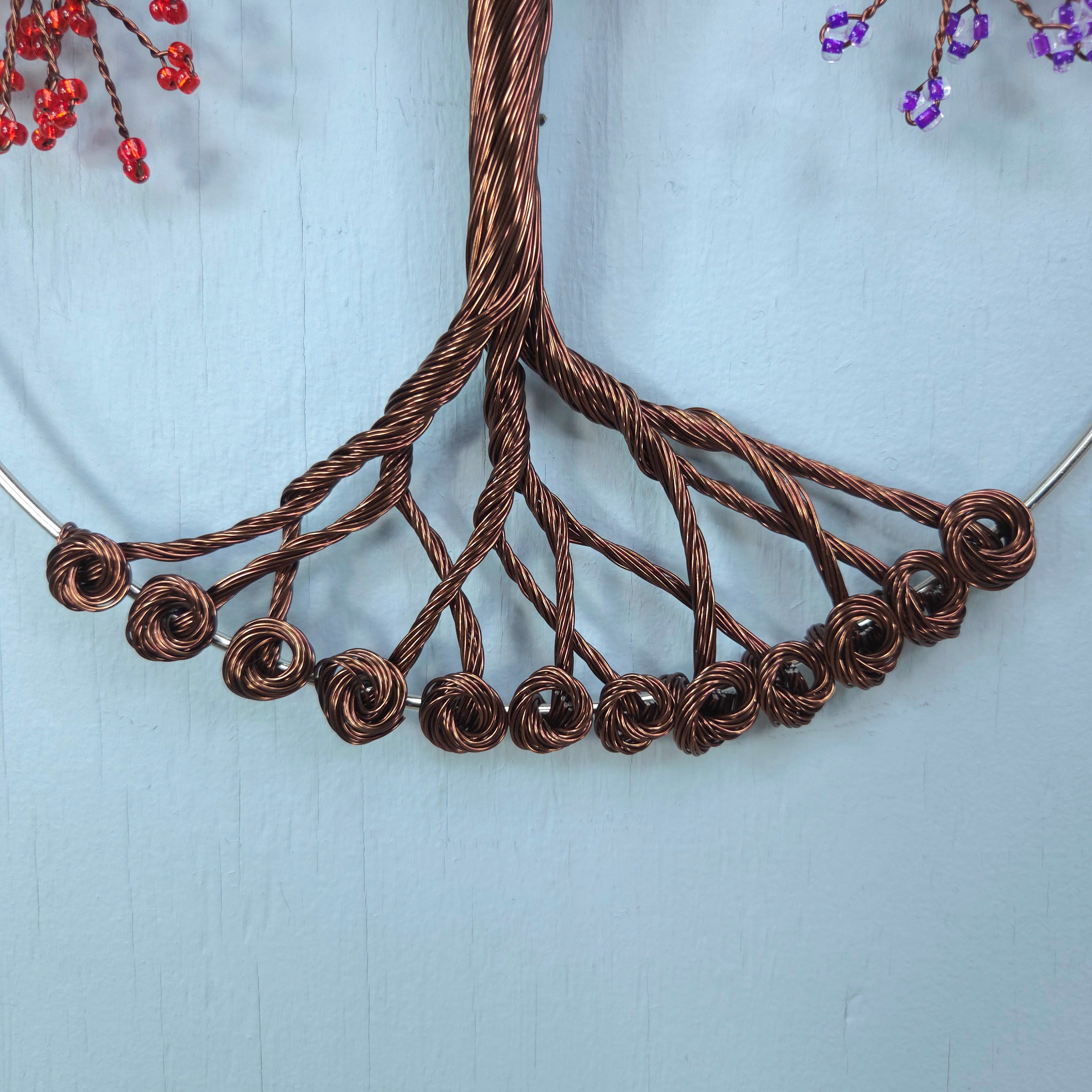 Close-up of a copper wire necklace on a light blue background