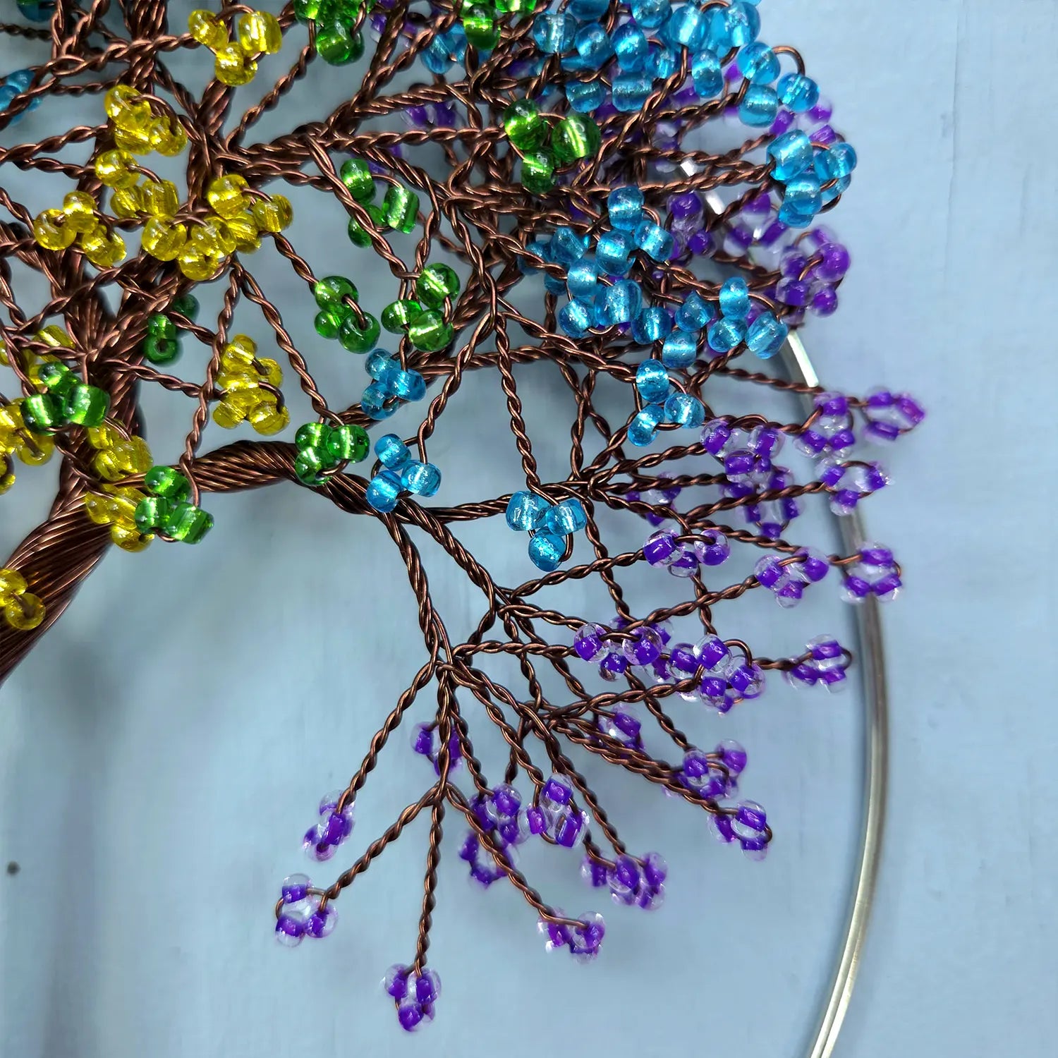Decorative tree made of wire and beads on a light blue background
