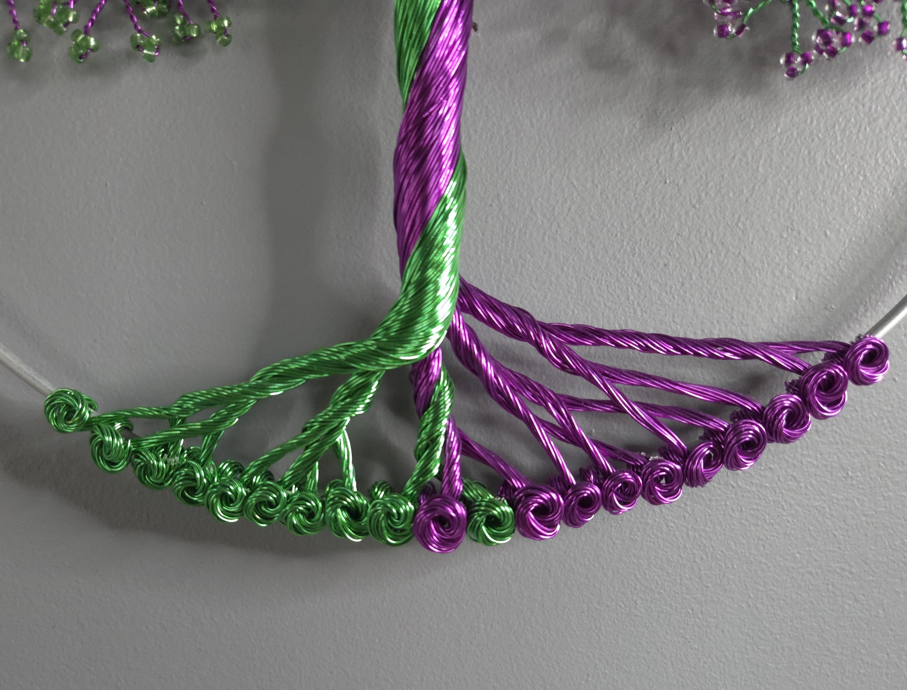 Close-up of green and purple braided wire on a gray background