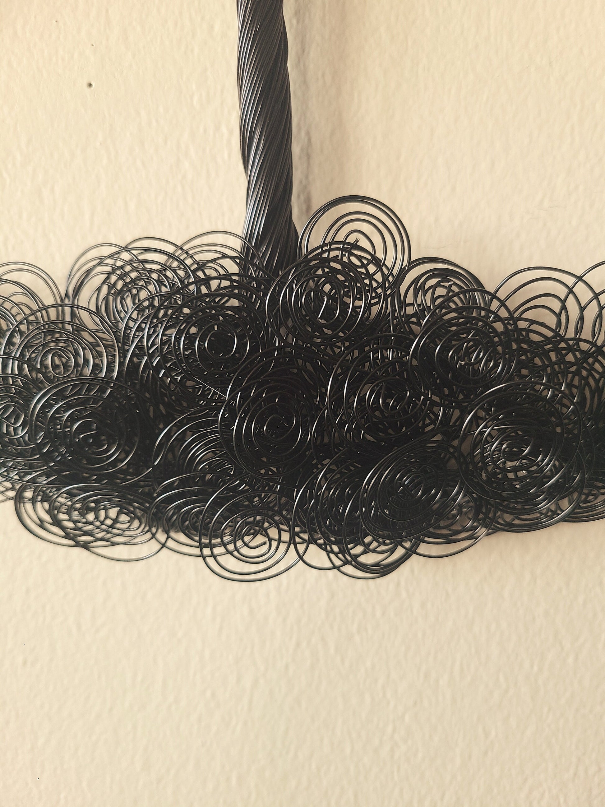 Close-up of black wire loops on a beige background
