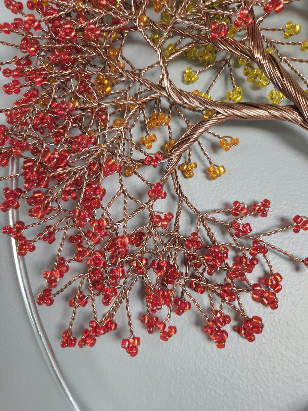 Decorative branch with red berries and gold wire on a light gray background