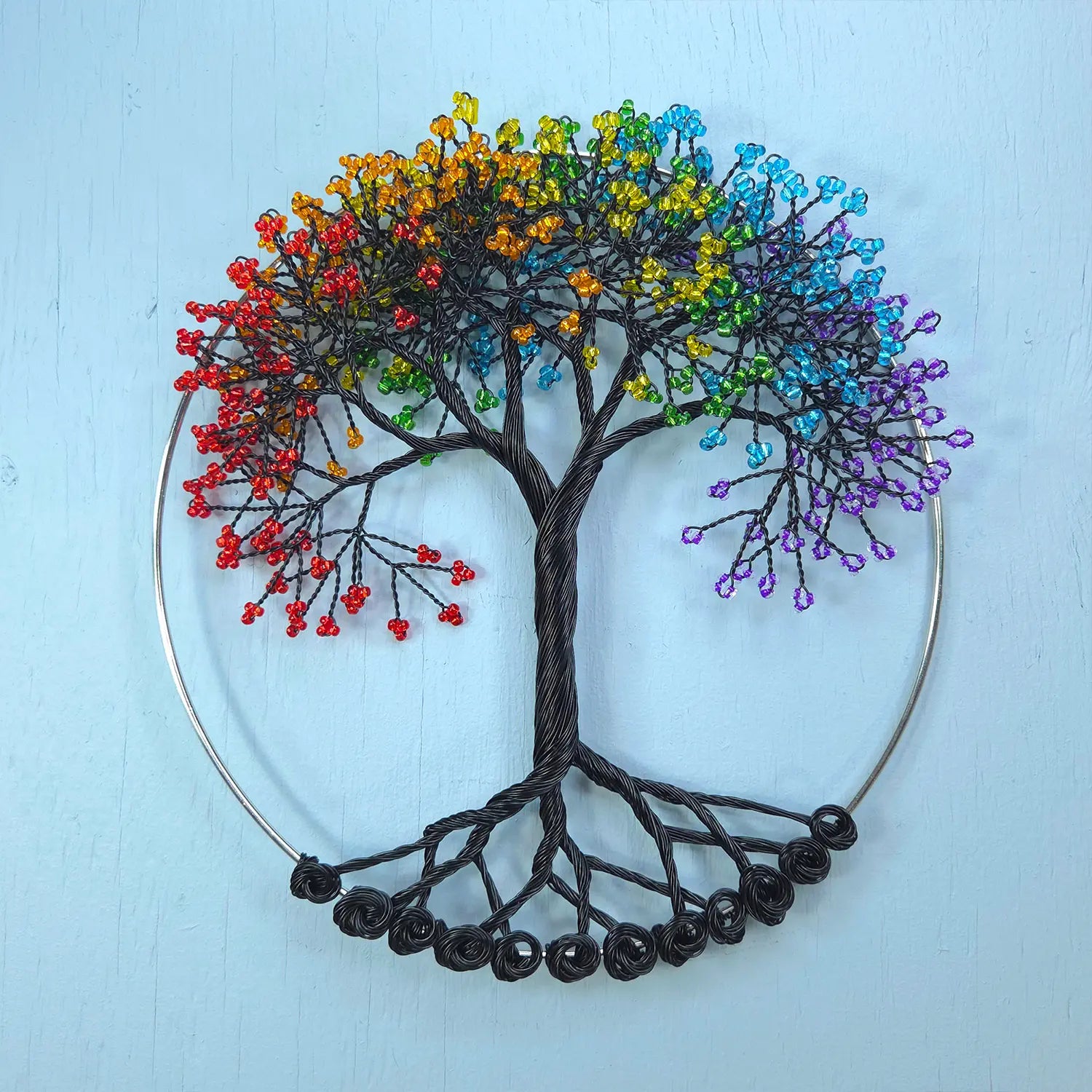 Colorful tree of life wall art on a light blue background