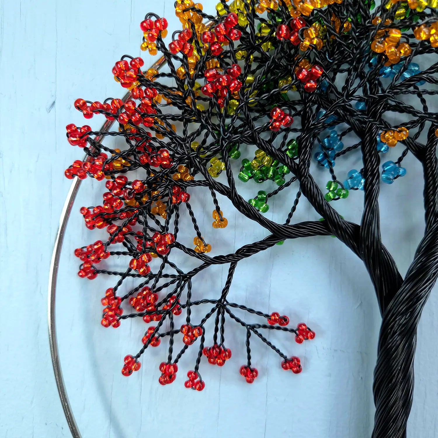 Decorative tree made of wire and beads on a light blue background