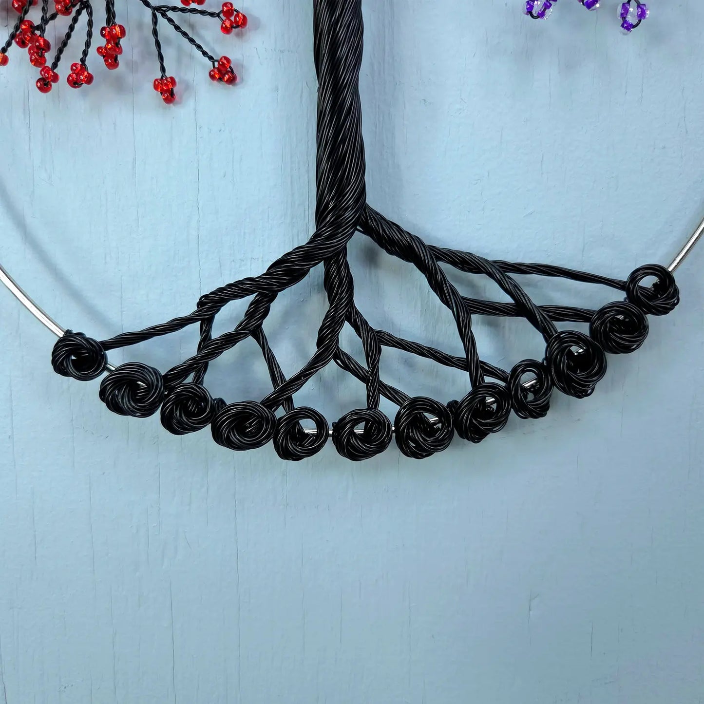 Black wire necklace on a light blue background