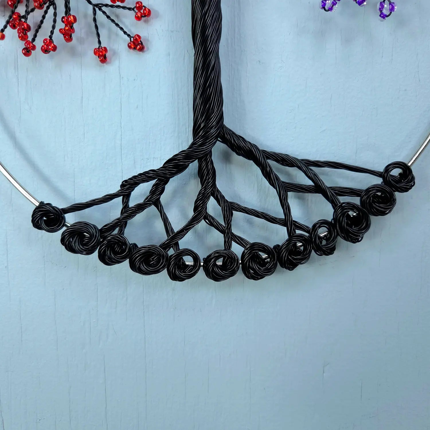 Black wire necklace on a light blue background