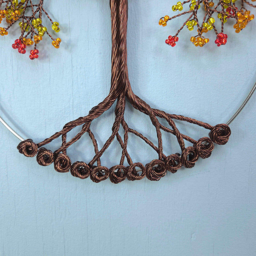 Brown wire necklace on a light blue background with floral decorations.