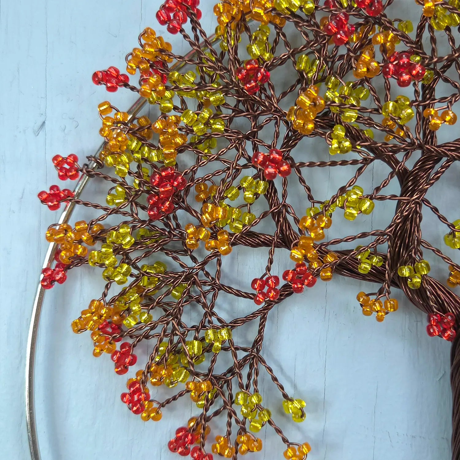 Decorative wreath with red and yellow berries on a light blue background