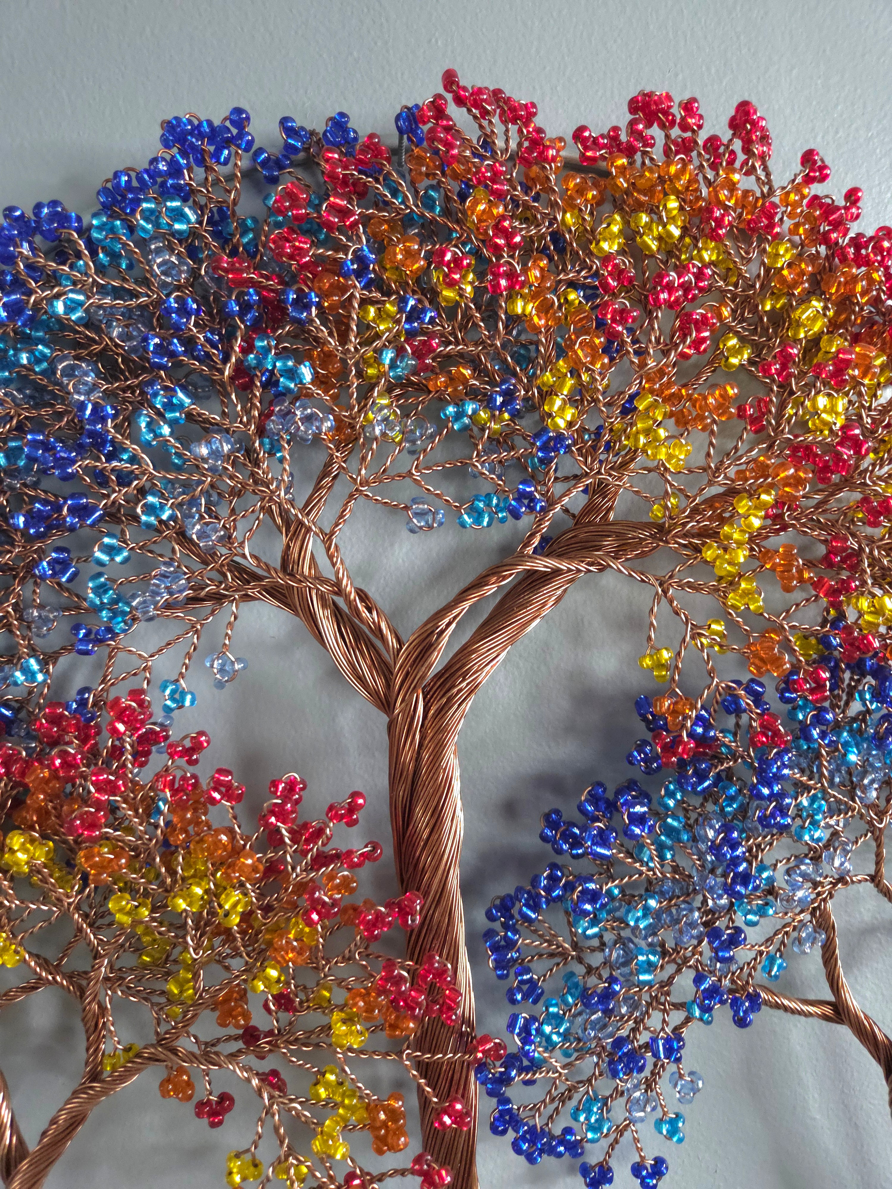 Colorful beaded tree sculpture on a gray background