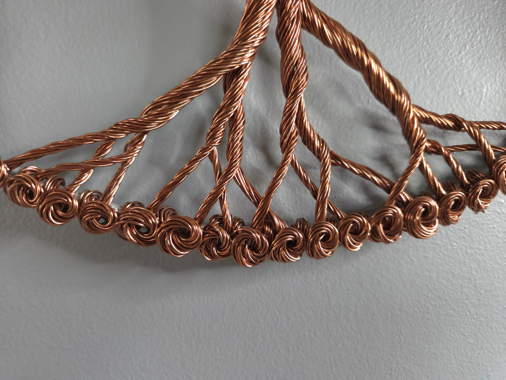 Copper wire necklace on a gray background