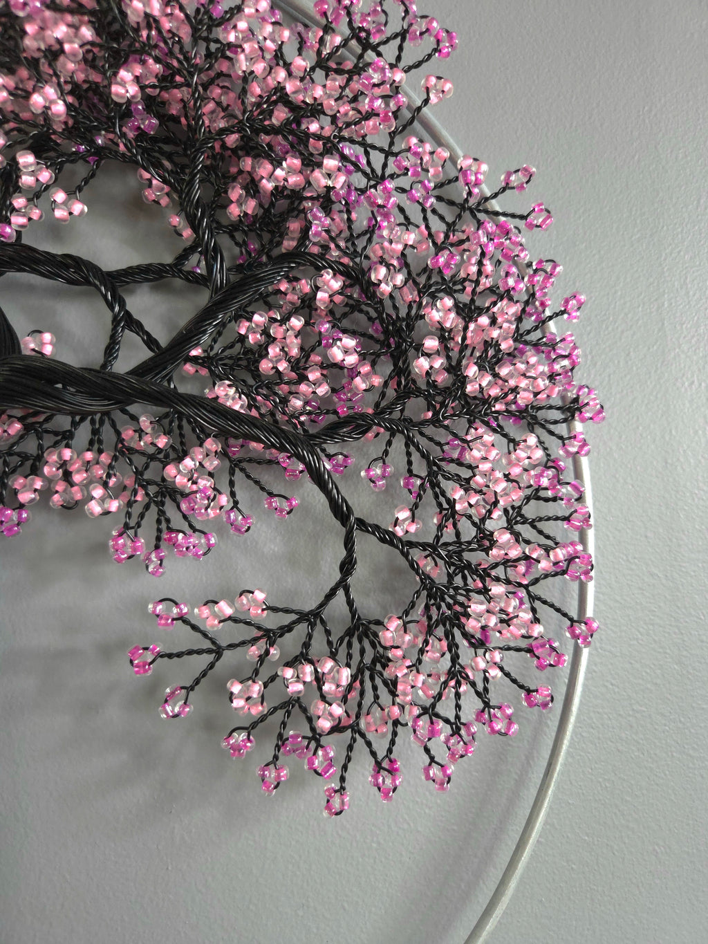 Decorative branch with pink beads on a gray background