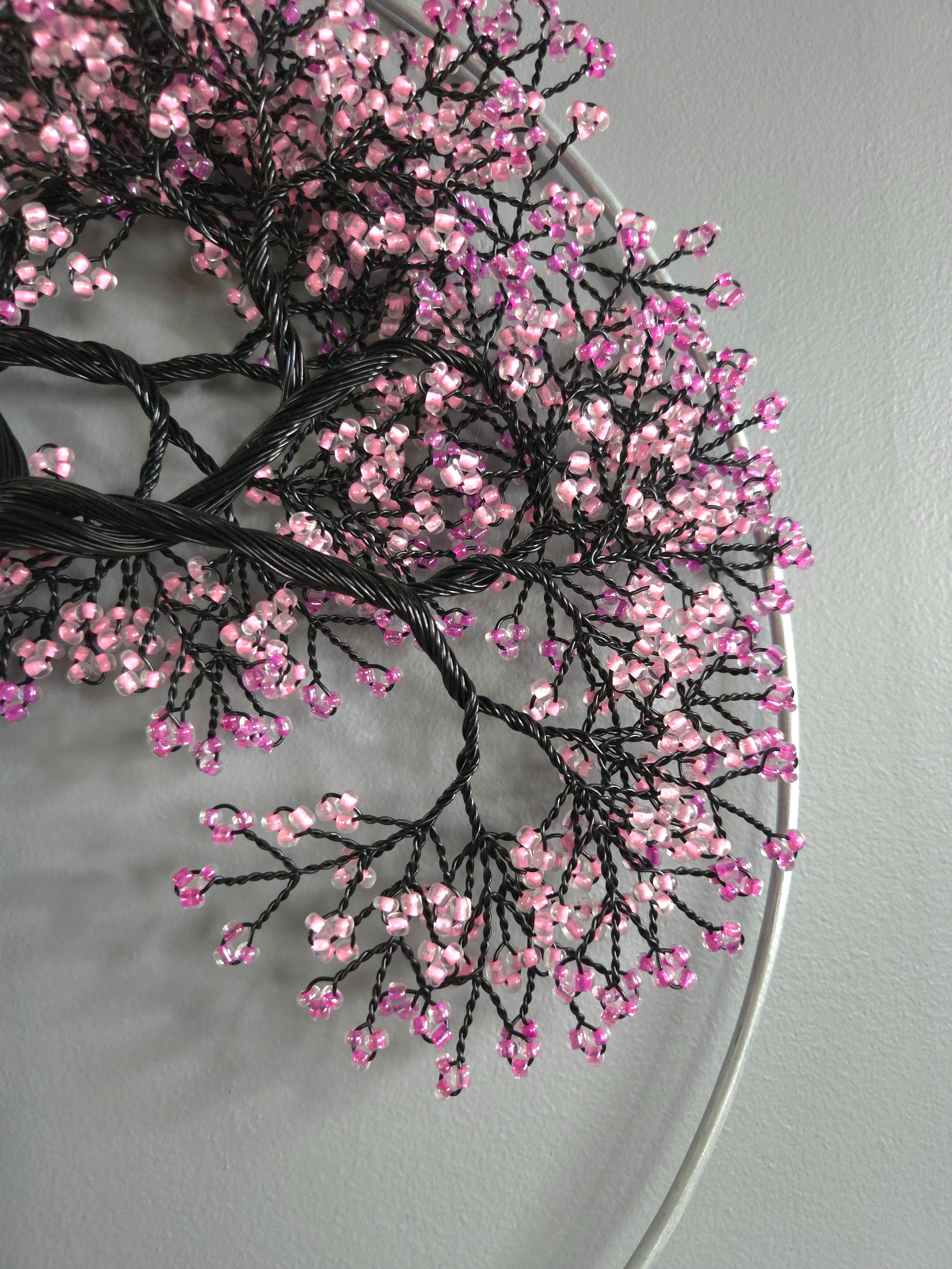 Decorative branch with pink beads on a gray background