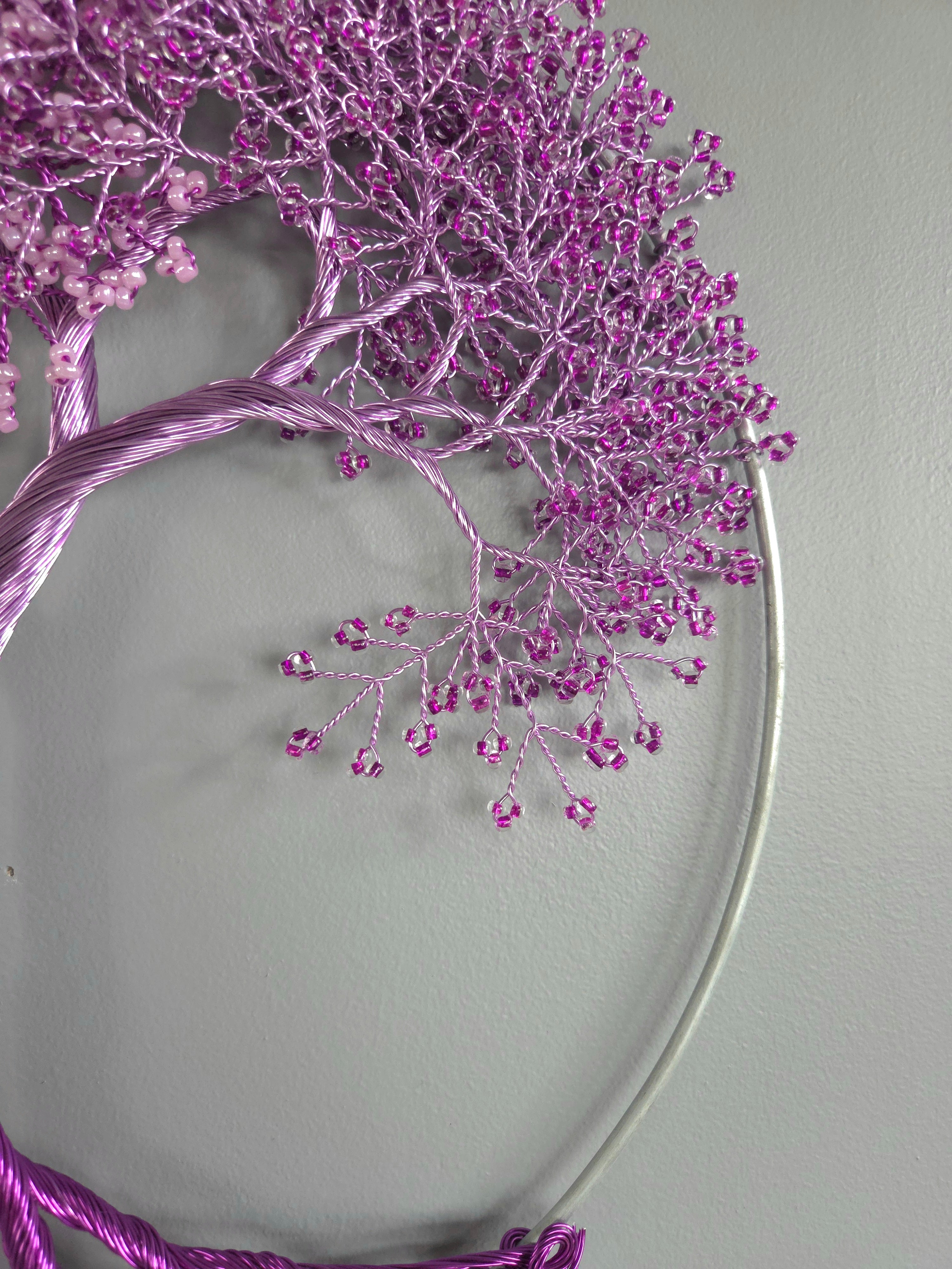 Decorative wreath with purple branches and beads on a gray background