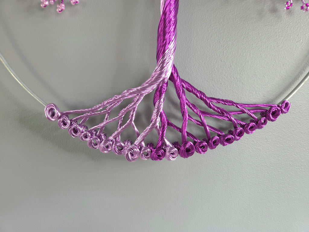 Close-up of a purple beaded necklace on a light gray background