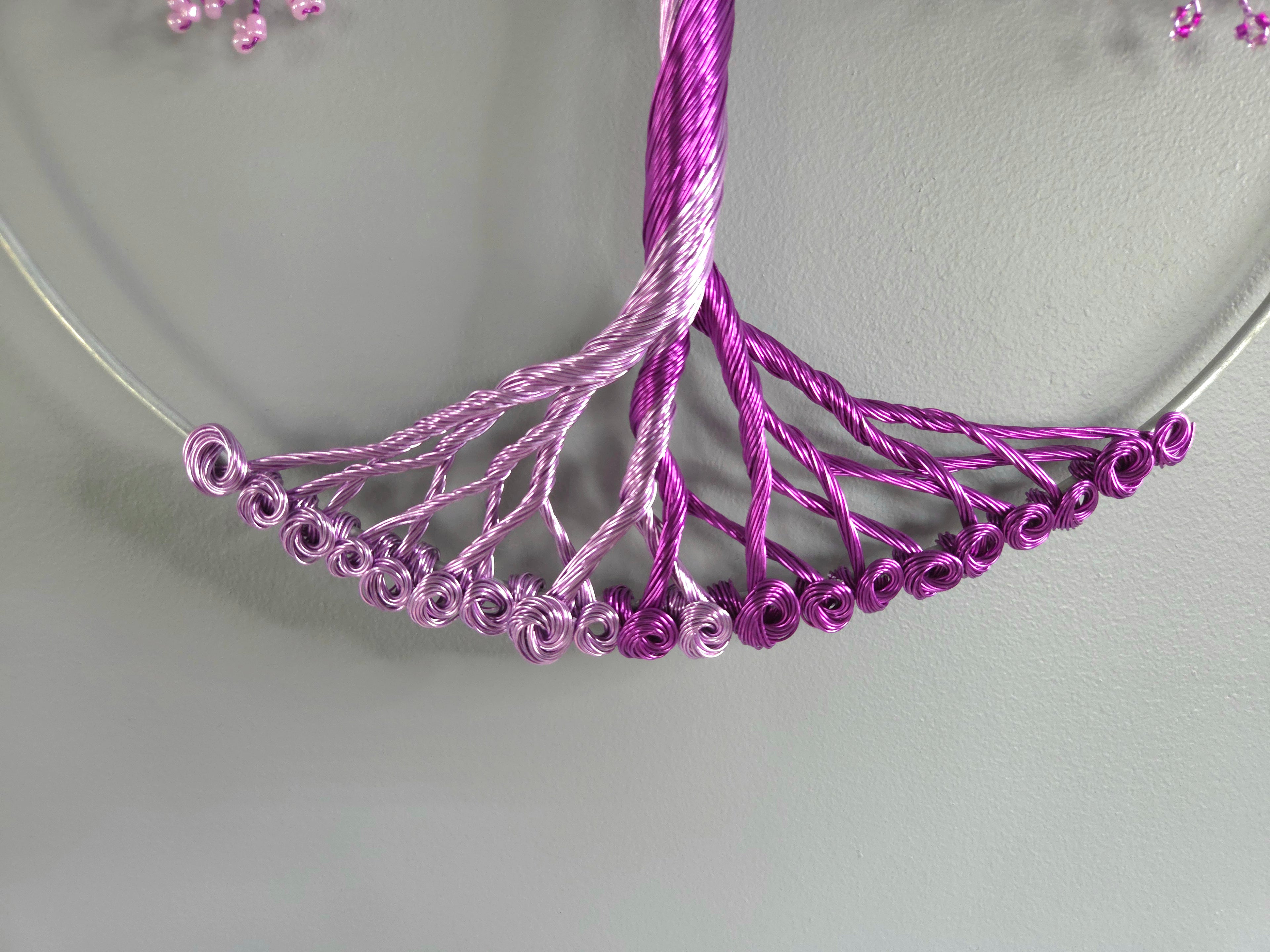 Close-up of a purple beaded necklace on a light gray background