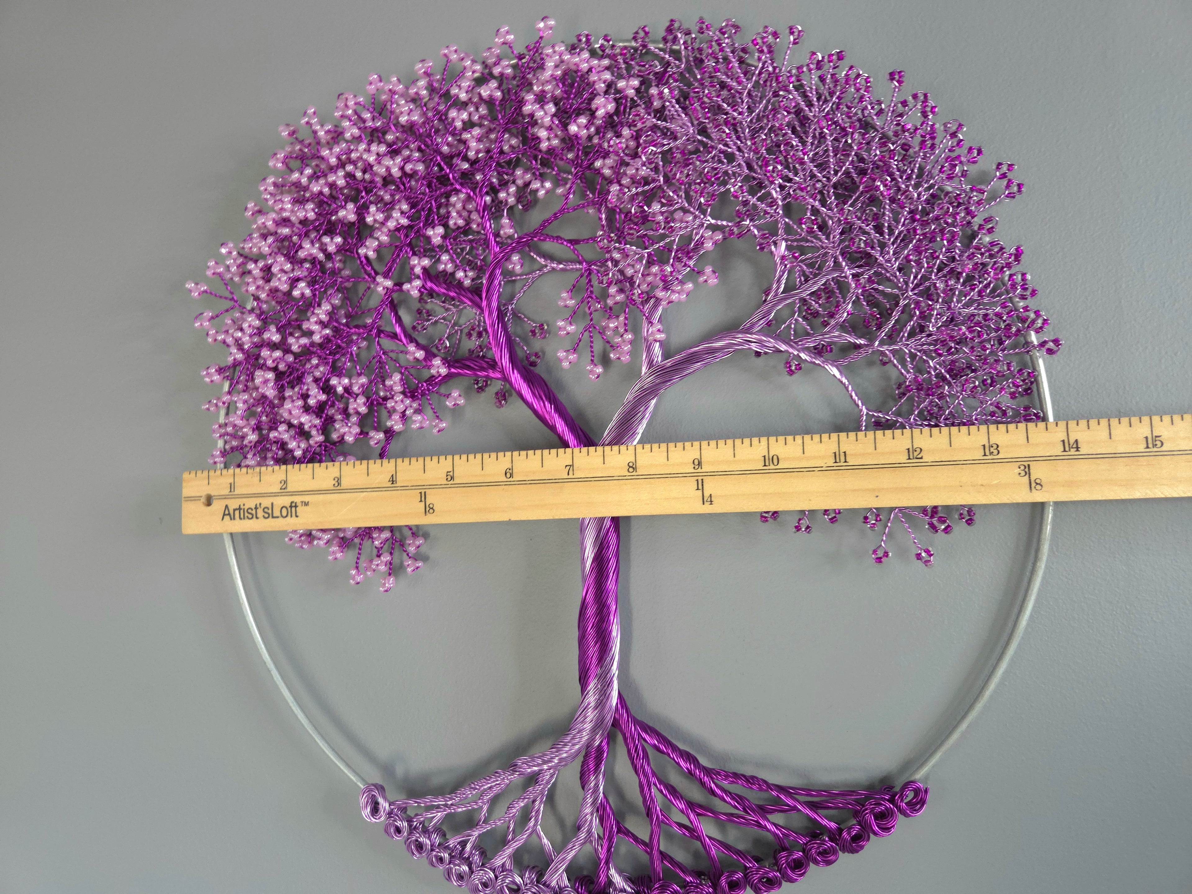 Purple decorative wall art with a ruler for scale on a gray background