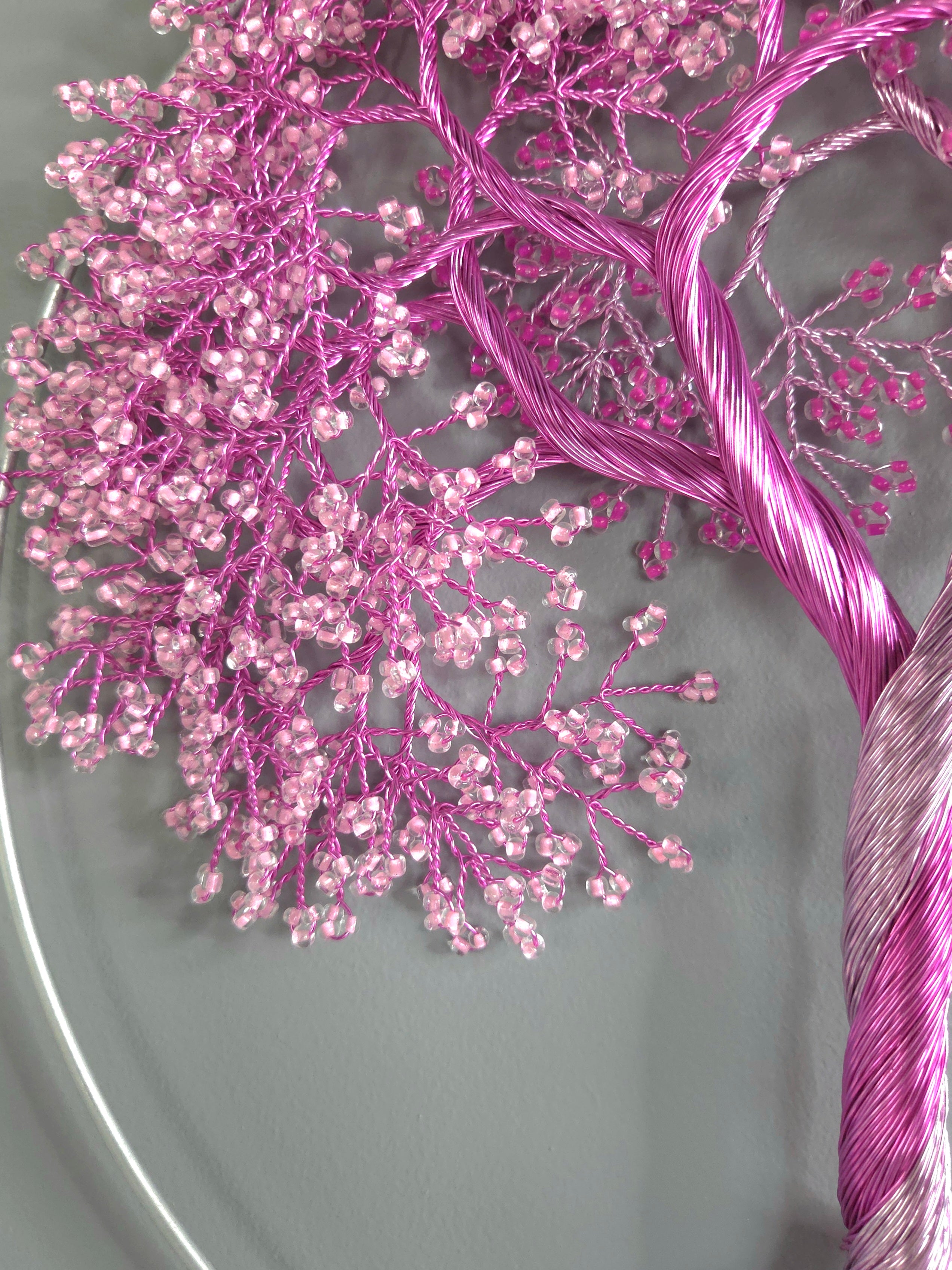 Decorative wall art of a tree with pink blossoms on a gray background