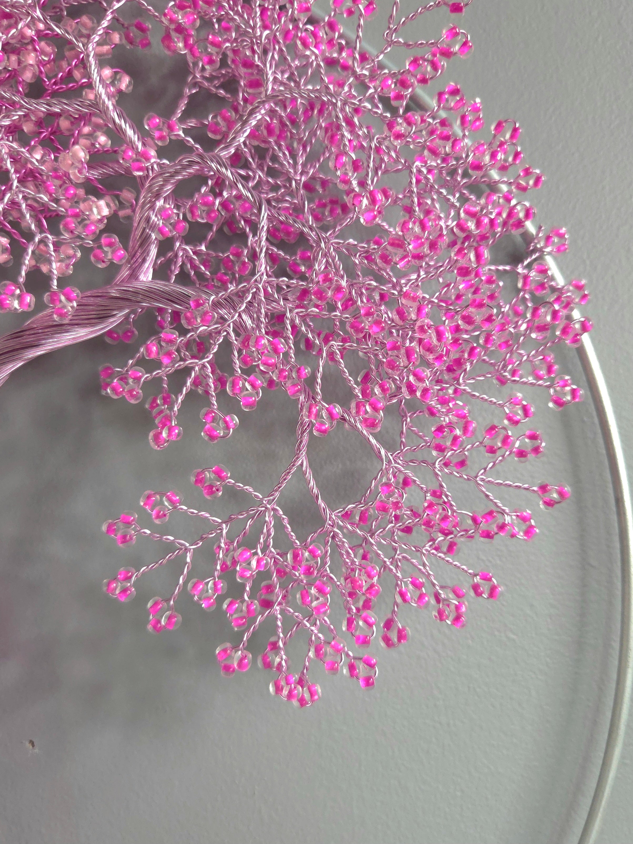 Decorative wall art of a tree with pink blossoms on a gray background