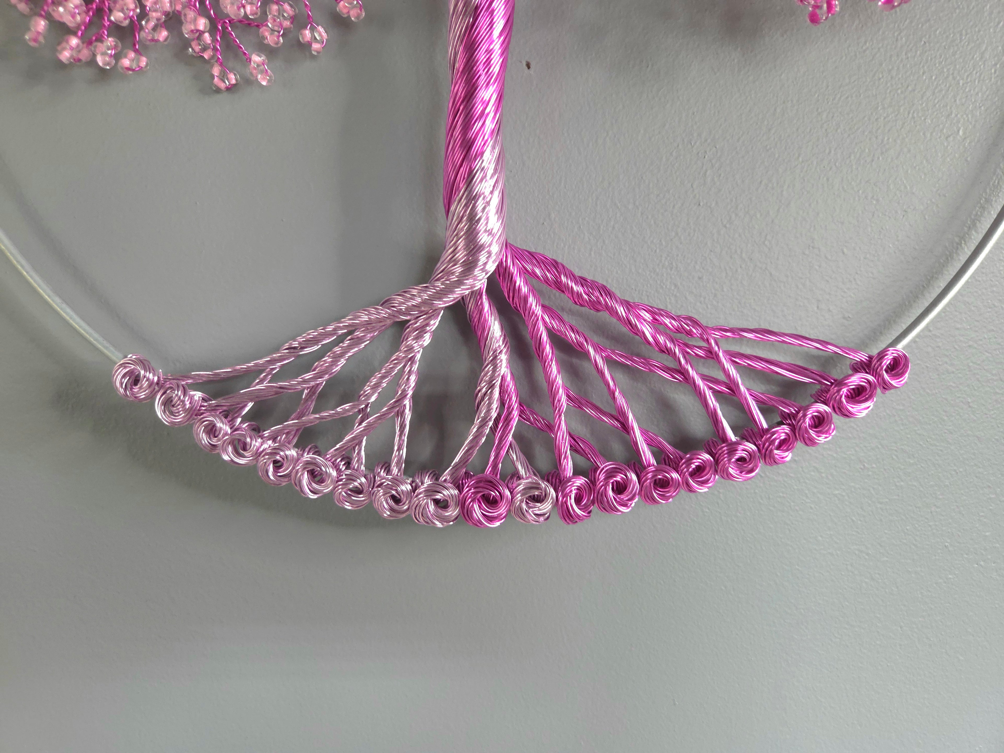 Decorative wall art of a tree with pink blossoms on a gray background