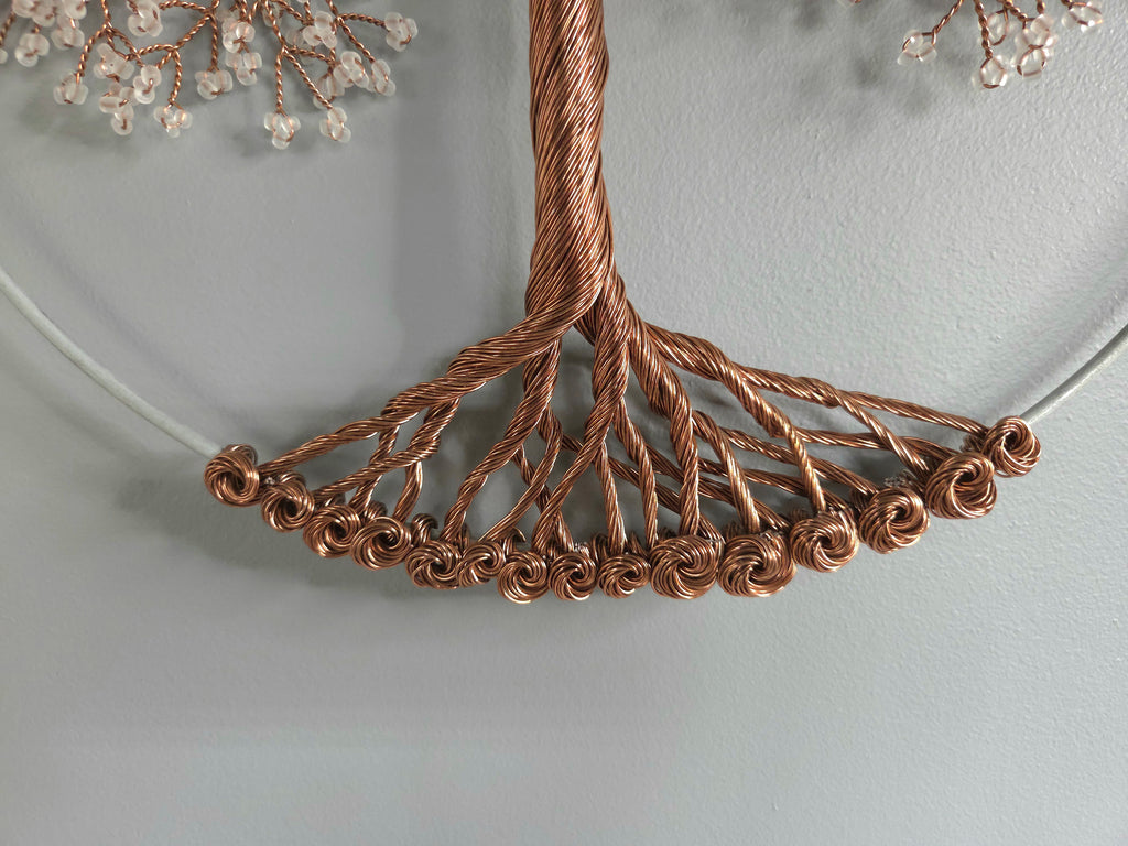 Close-up of a copper wire necklace on a light gray background