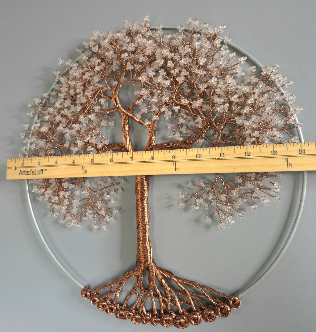 Decorative metal tree wall art with a ruler for scale on a gray background