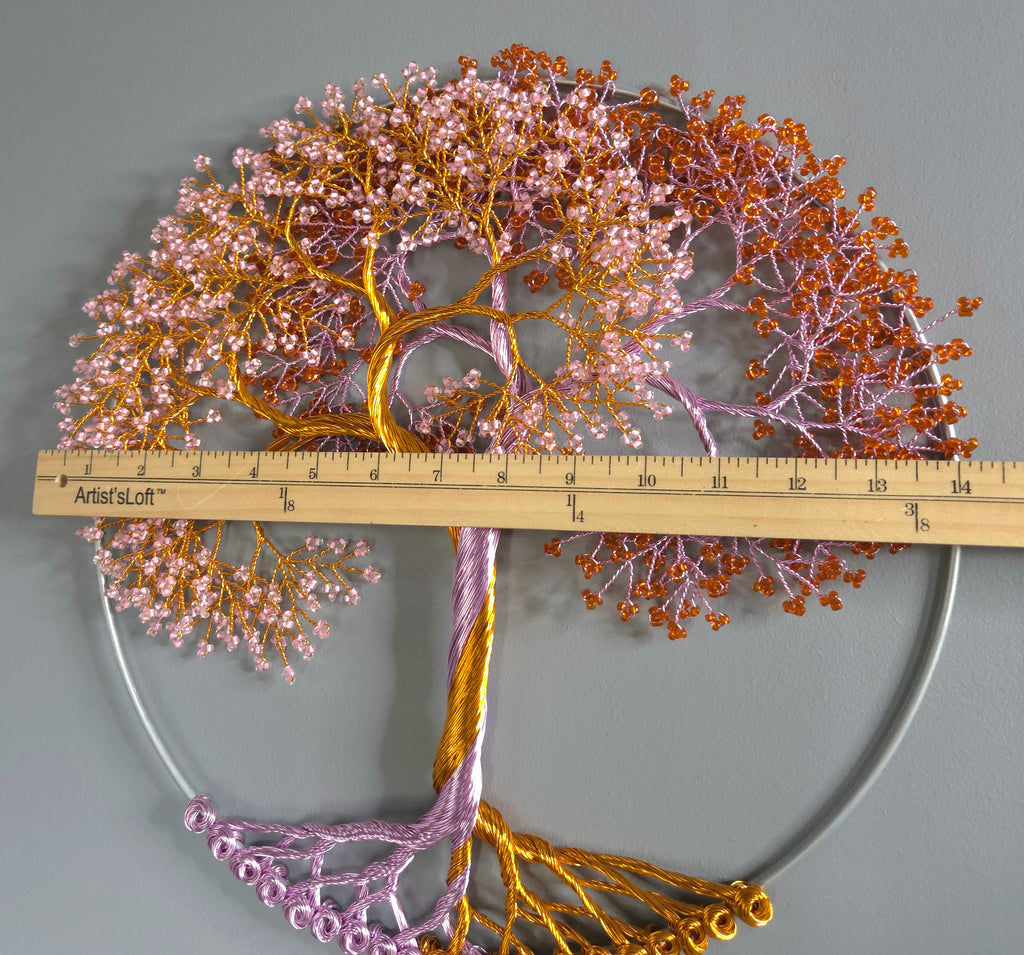 Decorative wall art of a tree with pink and gold branches, accompanied by a ruler for scale.