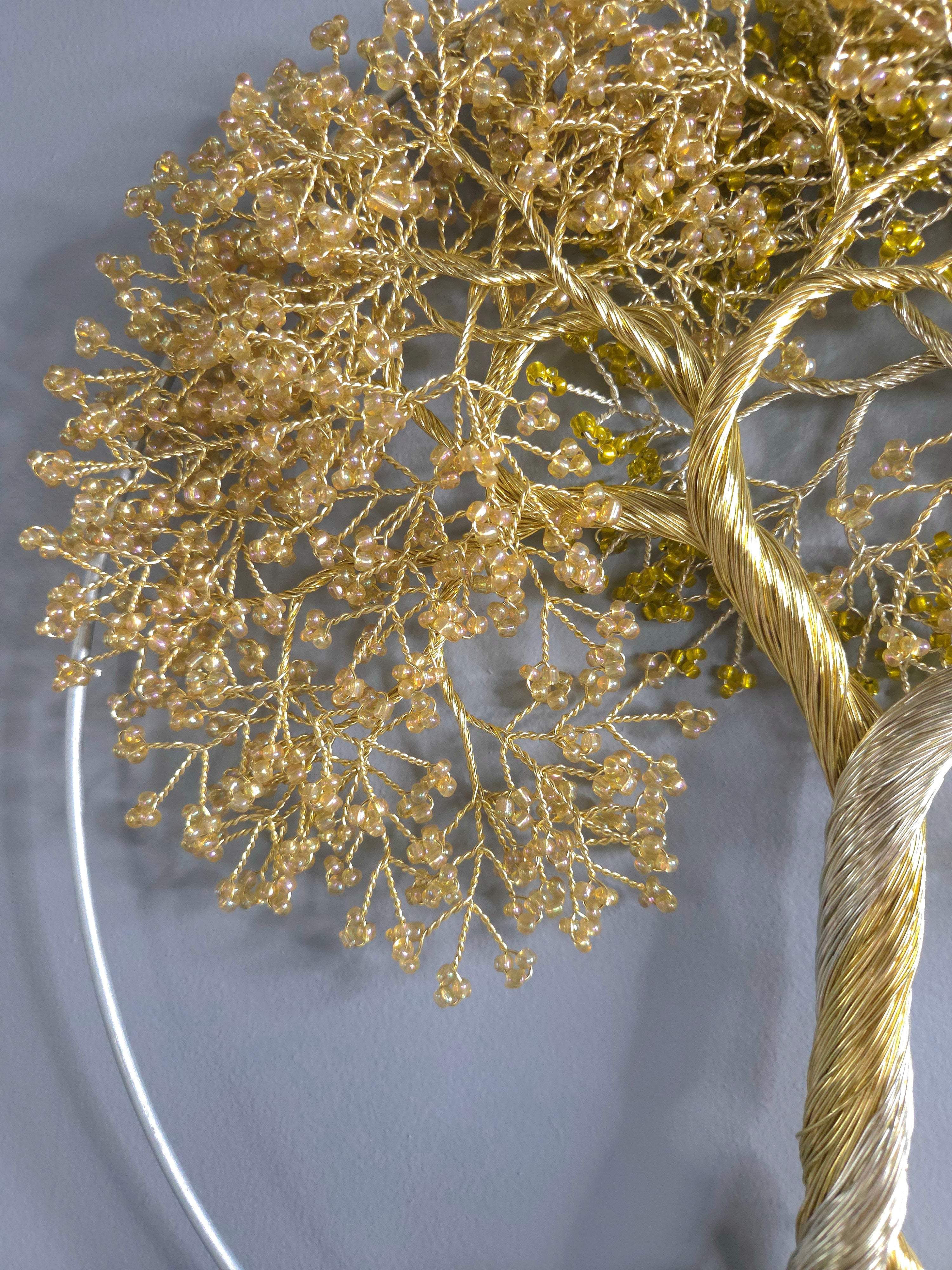 Decorative wall art of a gold tree with yellow leaves on a gray background