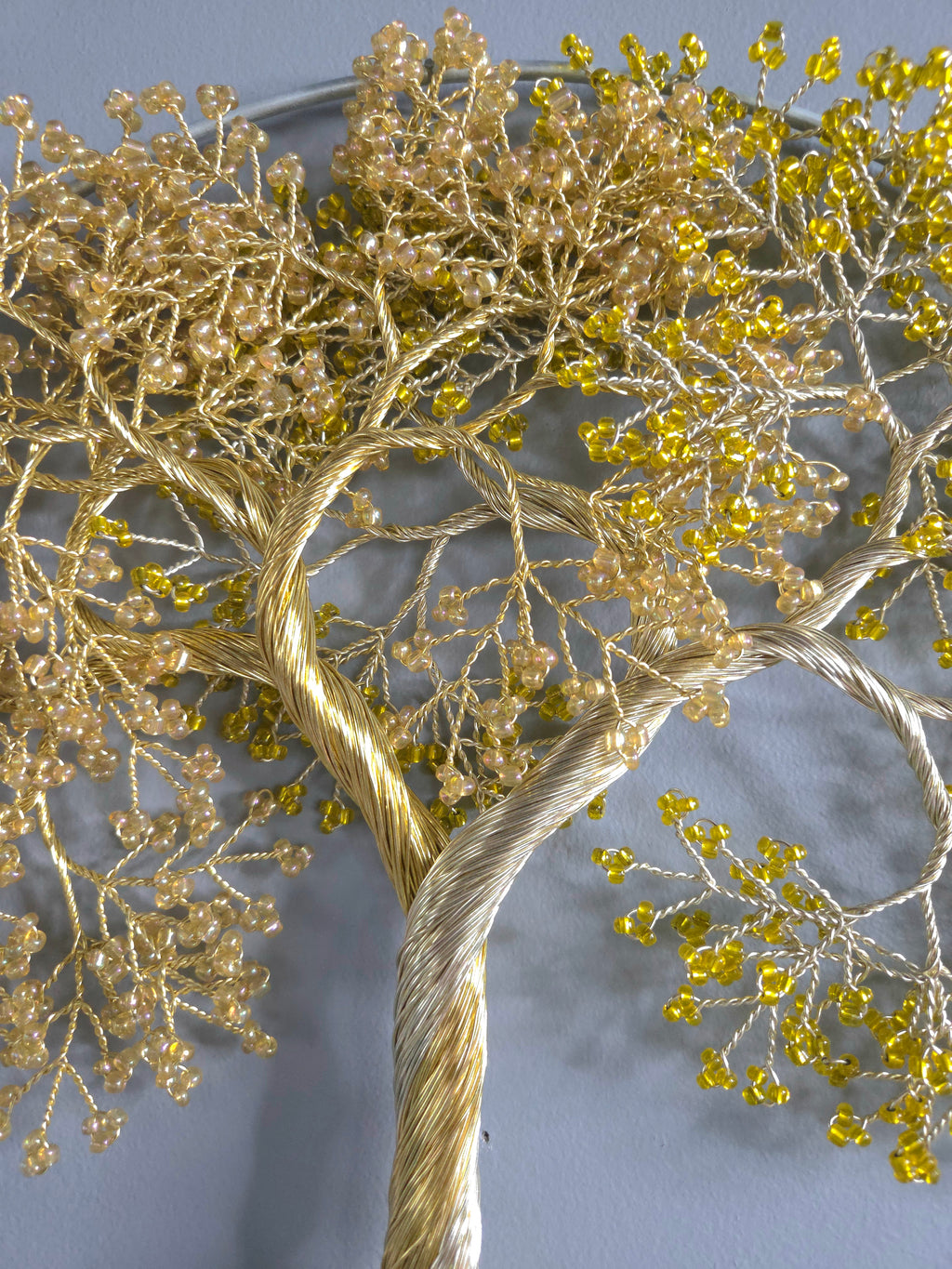 Decorative wall art of a gold tree with yellow leaves on a gray background