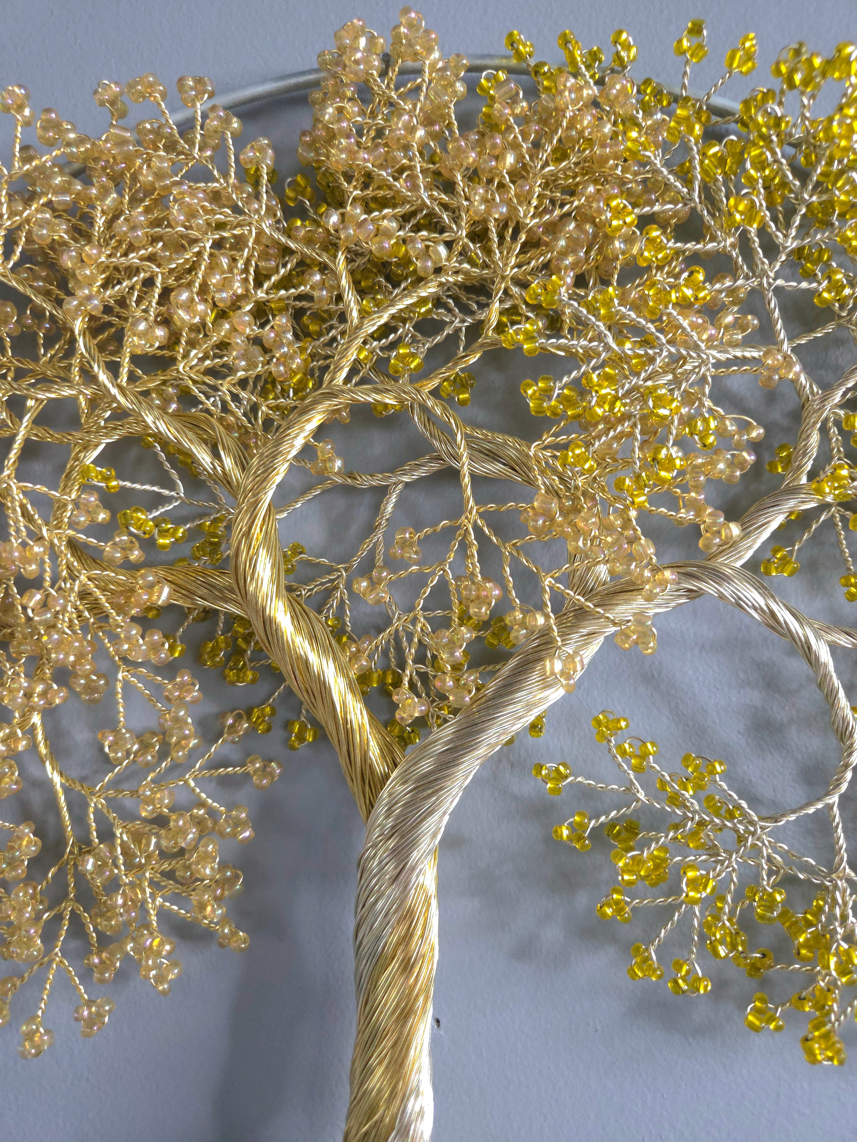 Decorative wall art of a gold tree with yellow leaves on a gray background