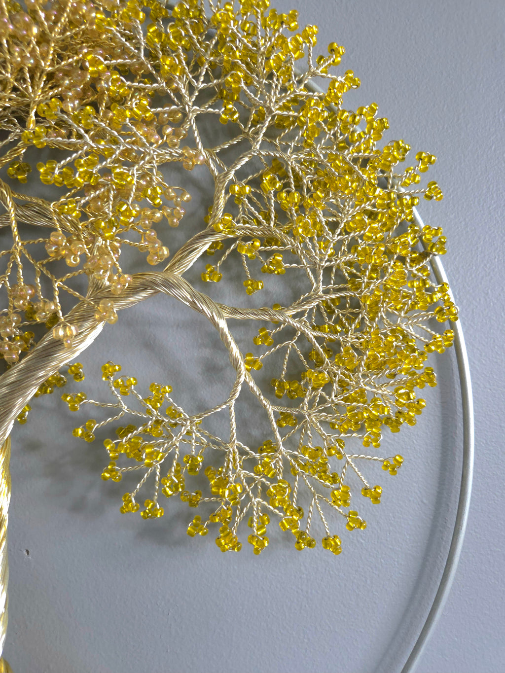 Decorative wall art of a gold tree with yellow leaves on a gray background