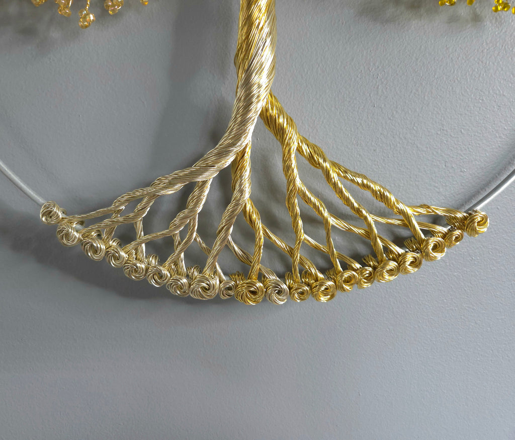 Decorative wall art of a gold tree with yellow leaves on a gray background