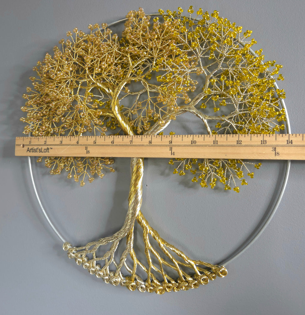 Decorative wall art of a gold tree with yellow leaves on a gray background